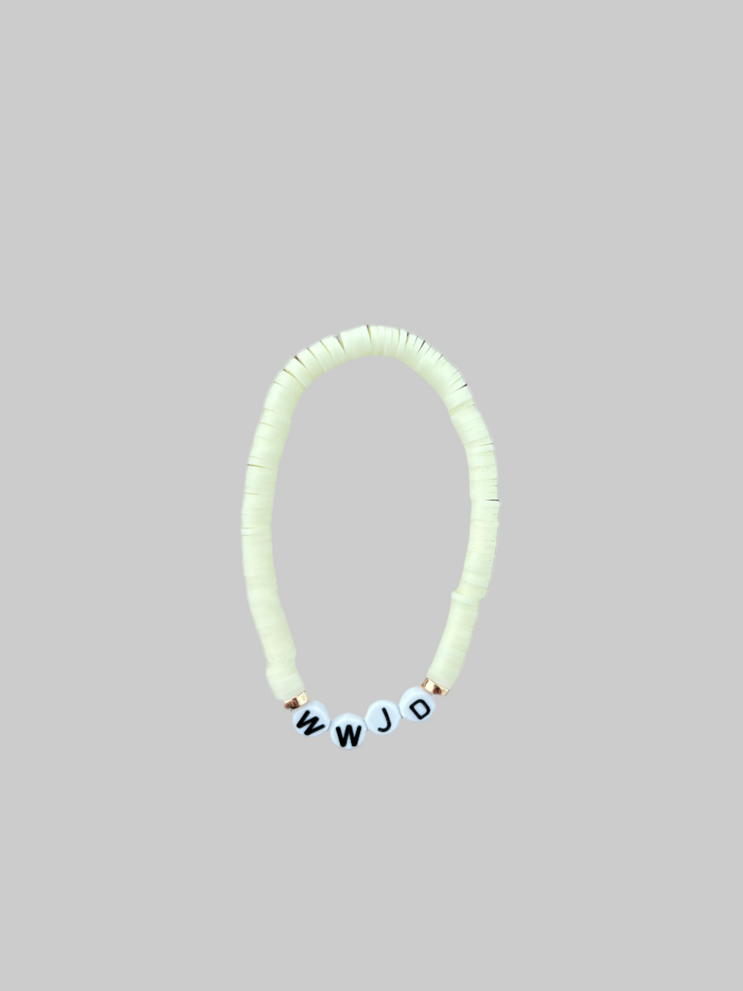 A beaded bracelet in a neutral cream color with the letters 'WWJD' displayed.