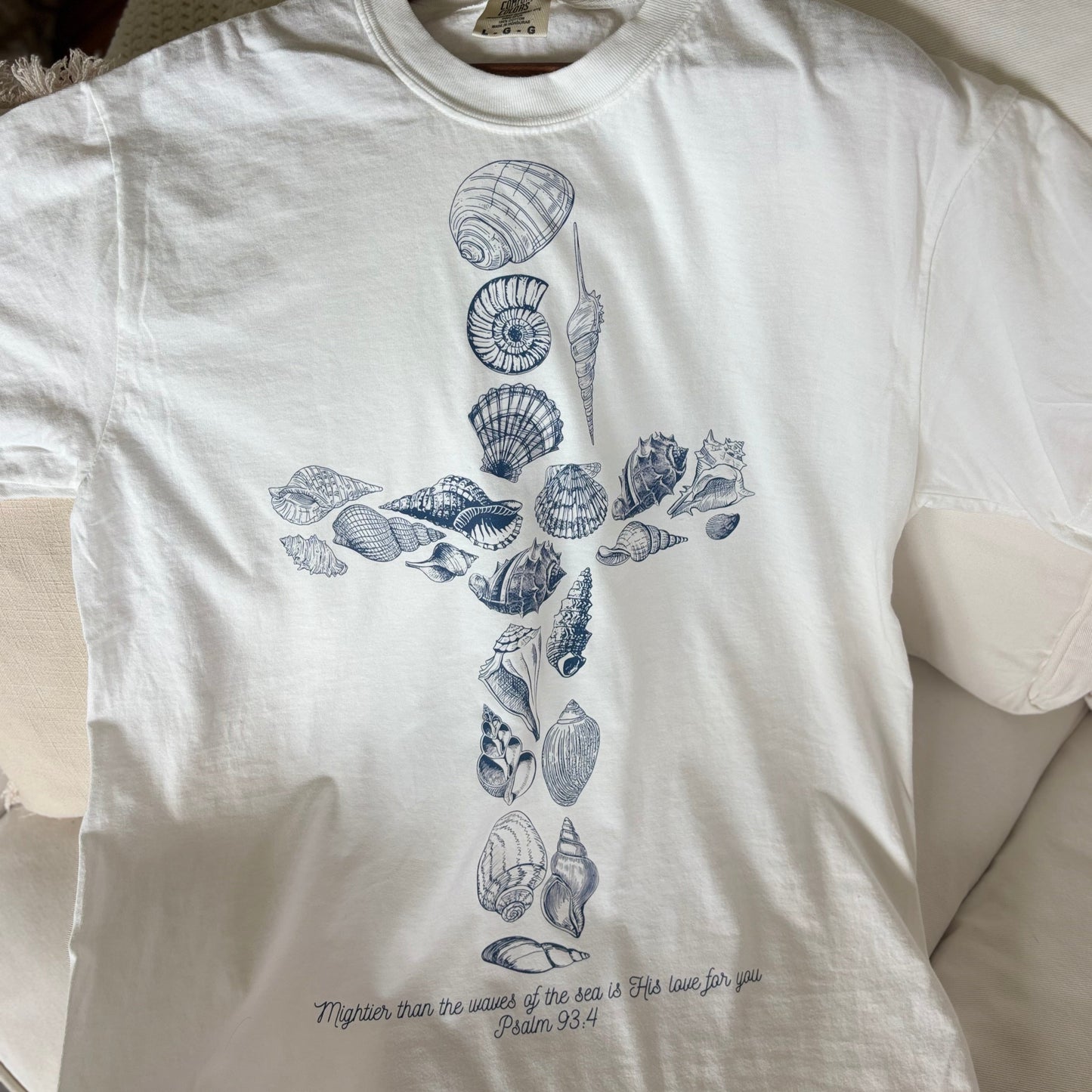 white shirt with seashells in the shape of a cross and a psalms bible verse