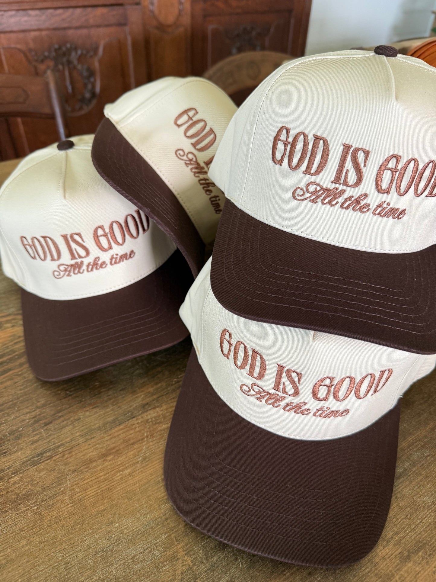 God is good all the time embroidered onto tan and brown trucker hats