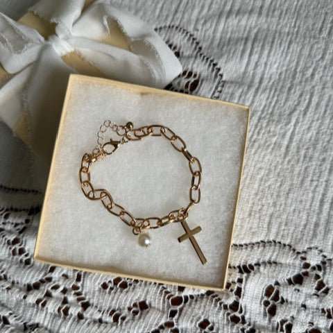 gold bracelet with cross and pearl charm