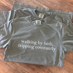 green shirt with text that says 'walking by faith tripping constantly.'